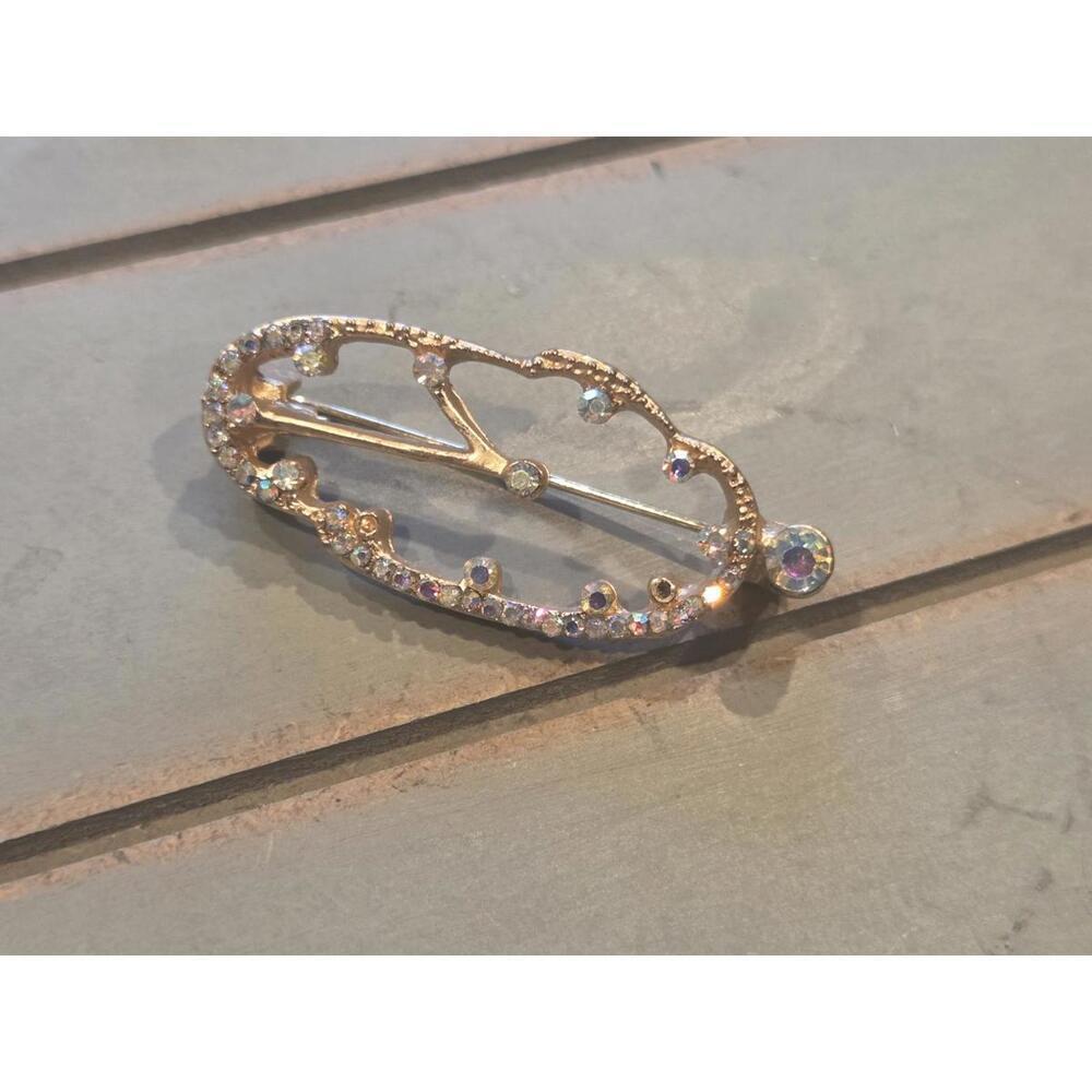 Golden with rhinestones melted clock brooch